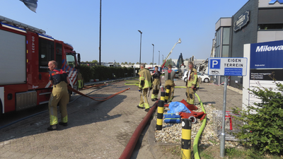 908942 Afbeelding van brandweerlieden die bezig zijn met het nablussen van het uitgebrande bedrijfsverzamelgebouw ...
